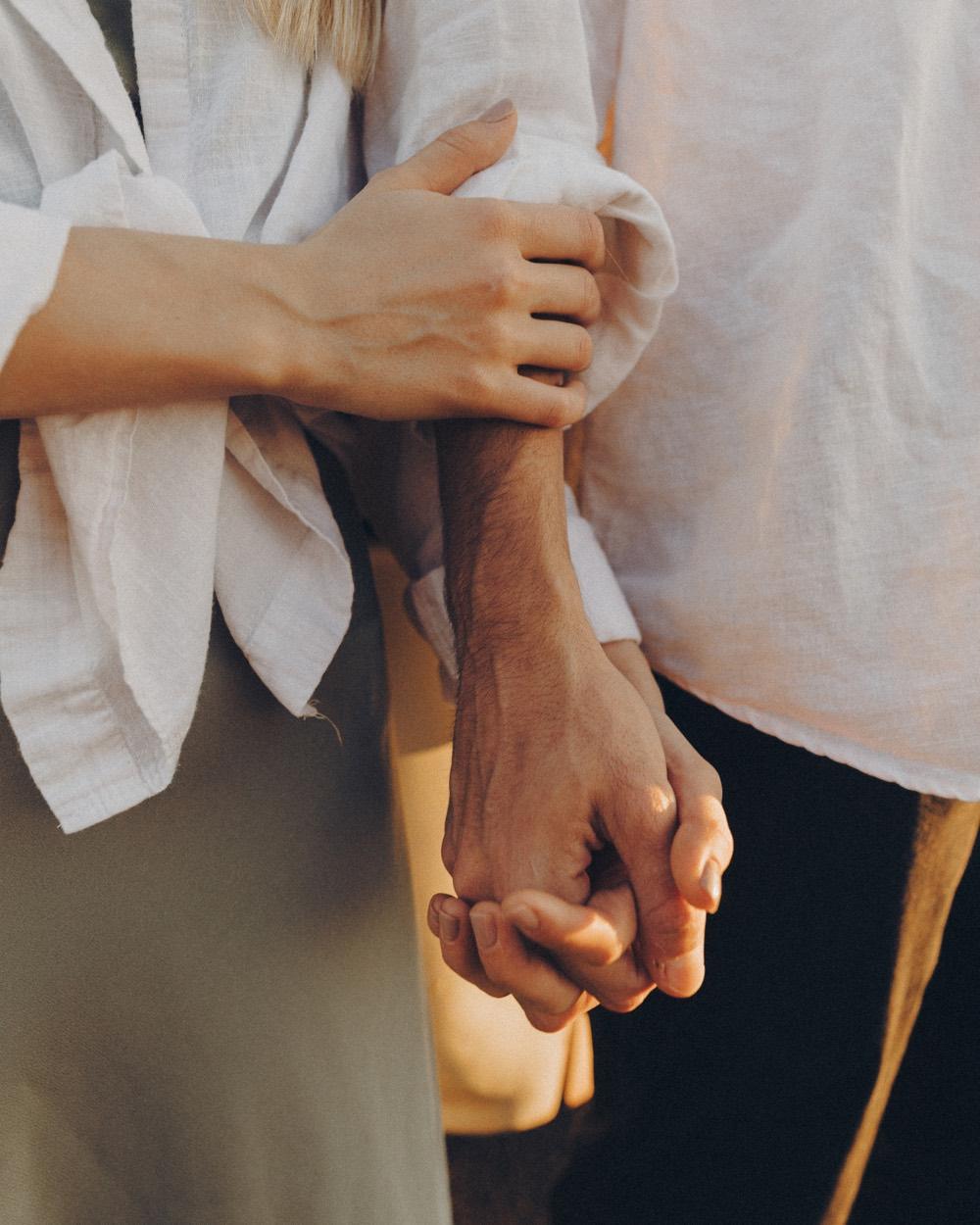 Twee mensen lopen arm in arm en houden elkaars hand vast